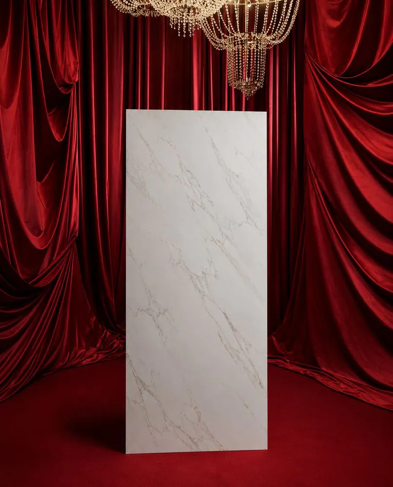 White statuario-look ORKAY slab stood on red velvet beneath a crystal chandelier